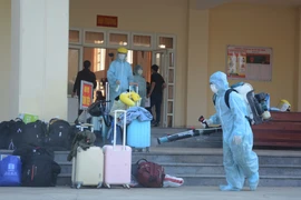 Khử trùng hành lý của công dân từ Hàn Quốc trở về. (Ảnh: Văn Dũng/TTXVN)