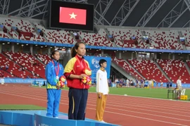 Vận động viên Lại Thị Ngọc Ánh (áo đỏ) hát quốc ca trong lễ trao giải. (Ảnh: Lê Hải-Việt Hải/TTXVN​)