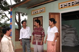 Cán bộ xã tuyên truyền, vận động người dân tích trữ lương thực nhằm phòng chống thiếu lương thực khi bị mưa lũ. (Ảnh: Trần Lê Lâm/TTXVN)