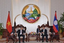 Thủ tướng Lào Thongsing Thamavong (phải) tiếp thân mật Bộ trưởng Hà Hùng Cường. (Ảnh: Phạm Kiên/TTXVN)