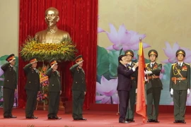 Chủ tịch nước Trương Tấn Sang gắn Danh hiệu Anh hùng Lao động lên lá cờ truyền thống của Ngân hàng Thương mại Cổ phần Quân đội. (Ảnh: Nguyễn Khang/TTXVN)