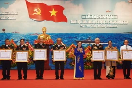 Bà Trần Thị Hà, Thứ trưởng Bộ Nội vụ, Trưởng Ban Thi đua-Khen thưởng Trung ương trao Quyết định của Chủ tịch nước tặng danh hiệu Anh hùng lực lượng vũ trang cho các cá nhân. (Ảnh: Lâm Khánh/TTXVN)