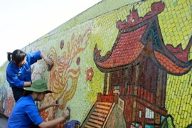 Các đoàn viên tham gia làm vệ sinh môi trường Con đường gốm sứ. (Ảnh: Đình Trân/TTXVN)