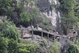 Thực hiện tháo dỡ hệ thống bậc thang lên núi Cái Hạ. (Ảnh: Ninh Đức Phương/TTXVN)