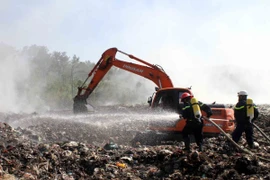 Dập lửa tại bãi rác. (Ảnh: Tá Chuyên/TTXVN)