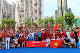 Tổng lãnh sự Trần Thanh Huân (giữa) chụp ảnh lưu niệm với cầu thủ hai đội. (Ảnh: Xuân Tuấn-Hoài Nam/Vietnam+)