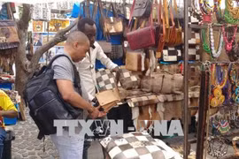 Khách du lịch tại một khu chợ bán hàng lưu niệm tại thành phố Cape Town. (Ảnh: Phi Hùng/TTXVN)