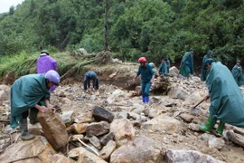 Các lực lượng công an, bộ đội, dân quân tự vệ tìm kiếm người mất tích tại trang trại nuôi cá nước lạnh ở bản Chu Va, xã Sơn Bình, huyện Tam Đường. (Ảnh: Quý Trung/TTXVN)