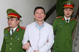 Cảnh sát dẫn giải bị cáo Trịnh Xuân Thanh về trại giam. (Ảnh: An Đăng/ TTXVN)