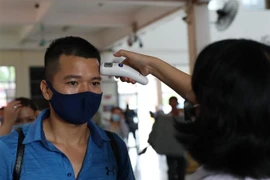 Đo thân nhiệt hành khách tại bến xe Mỹ Đình (Hà Nội). (Ảnh: Danh Lam/TTXVN)