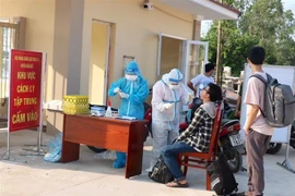 Lực lượng chức năng đưa các trường hợp trở về từ quận Gò Vấp, thành phố Hồ Chí Minh vào cách ly tập trung xã Suối Rao, huyện Châu Đức và thực hiện lấy mấu xét nghiệm. (Ảnh: Hoàng Nhị/TTXVN)