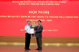 Bí thư Đảng ủy Khối các cơ quan Trung ương Huỳnh Tấn Việt trao quyết định và tặng hoa tân Bí thư Đảng ủy Thanh tra Chính phủ Đoàn Hồng Phong (trái). (Nguồn: thanhtra.com.vn)