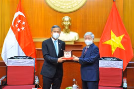 Chủ tịch Ủy ban Trung ương Mặt trận Tổ quốc Việt Nam Đỗ Văn Chiến và Bộ trưởng Bộ Ngoại giao Cộng hòa Singapore Vivian Balakrishnan trao đổi quà lưu niệm. (Ảnh: Minh Đức/TTXVN)