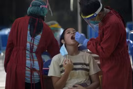 Nhân viên y tế lấy mẫu xét nghiệm COVID-19 tại Jakarta, Indonesia. (Ảnh: THX/TTXVN)