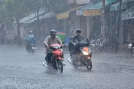 Mưa trắng xóa khiến tầm nhìn hạn chế, gây nguy hiểm cho người đi đường. (Ảnh: TTXVN phát)