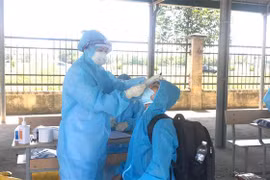 Nhân viên y tế lấy mẫu xét nghiệm cho người dân. (Ảnh: Hoa Mai/TTXVN)