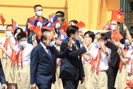 Chủ tịch nước Nguyễn Xuân Phúc và Tổng Bí thư, Chủ tịch nước CHDCND Lào Thongloun Sisoulith với thiếu nhi Thủ đô Hà Nội tại lễ đón. (Ảnh: Lâm Khánh/TTXVN)