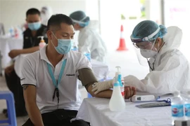 Khám sáng lọc trước khi tiêm vaccine cho công nhân tại Bắc Giang. (Ảnh: Danh Lam/TTXVN)