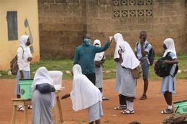 Kiểm tra thân nhiệt của học sinh tại một trường học ở thị trấn Iseyin, bang Oyo, Nigeria. (Ảnh: THX/TTXVN)