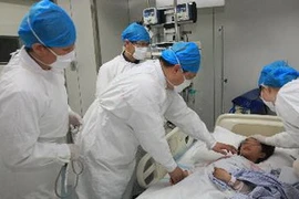 Nhân viên y tế chăm sóc em bé bị nhiễm cúm H7N9 tại bệnh viện Ditan Bắc Kinh ngày 12/4. (Nguồn: THX/TTXVN)