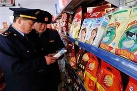 Kiểm tra sữa tại một siêu thị ở tỉnh Sơn Đông, Trung Quốc. (Ảnh: AP) 