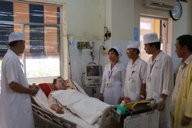 Bác sỹ Bệnh viện Đa khoa Sóc Trăng thăm hỏi bệnh nhân Trần Tuấn Quốc. (Ảnh: Chanh Đa​/TTXVN)