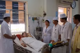 Bác sỹ Bệnh viện Đa khoa Sóc Trăng thăm hỏi bệnh nhân Trần Tuấn Quốc. (Ảnh: Chanh Đa​/TTXVN)