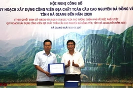 Thứ trưởng Bộ Xây dựng Nguyễn Đình Toàn trao quy hoạch xây dựng Công viên Địa chất toàn cầu Cao nguyên đá Đồng Văn đến năm 2030 cho Chủ tịch UBND tỉnh Hà Giang Nguyễn Văn Sơn. (Ảnh: Minh Tâm/Vietnam+)