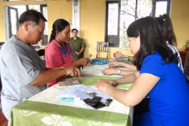 Người dân xã Lộc Điền nhận tiền bồi thường. (Ảnh: Tường Vi/TTXVN)
