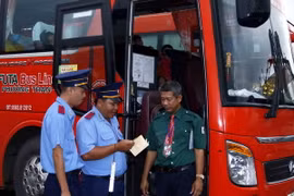 Thanh tra giao thông Cà Mau tiến hành kiểm tra thủ tục hành chính trước giờ xe khách xuất bến. (Nguồn: TTXVN)