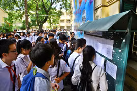 Thí sinh xem số báo danh và phòng thi tại điểm thi trường Trung học phổ thông Việt Đức. (Ảnh: Minh Quyết/TTXVN)