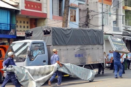 Lực lượng chức năng tiến hành tháo dỡ nhiều trường hợp nhà dân dựng mái che, biển hiệu chiếm vỉa hè đường Nguyễn Đình Chiểu (phường Đa Kao, quận 1). (Ảnh: Mạnh Linh/TTXVN)