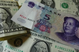 Đồng USD (trái) và nhân dân tệ (phải). (Nguồn: AFP/TTXVN)