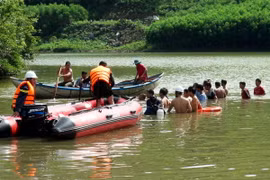Lực lượng chức năng tiến hành tìm kiếm thi thể các nạn nhân. (Ảnh: Phước Ngọc/TTXVN)