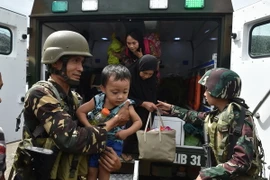 Binh sỹ Philippines giúp sơ tán người dân khỏi các khu vực xung đột tại Marawi. (Nguồn: AFP/TTXVN)