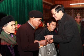 Chủ tịch nước Trương Tấn Sang tặng quà cho các hộ nghèo của xã Kim Bình, huyện Chiêm Hóa, Tuyên Quang, tháng 2/2012. (Ảnh: Nguyễn Khang/TTXVN)