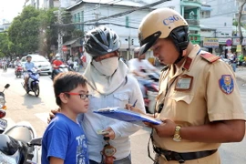 TP.HCM: Nhiều phụ huynh vẫn "lơ là" đội mũ bảo hiểm cho con
