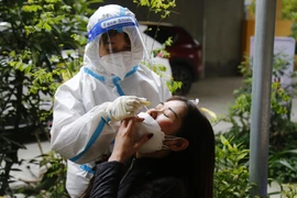 Nhân viên y tế xét nghiệm COVID-19 cho người dân. (Ảnh: Nam Sương/TTXVN)