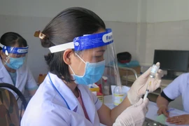 Lực lượng y tế triển khai tiêm vaccine cho người dân. (Ảnh: Dư Toán/TTXVN)