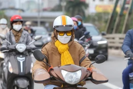 Người dân trang bị đầy đủ áo, khăn chống rét và găng tay khi ra đường. (Ảnh: Tuấn Đức/TTXVN)