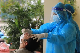 Nhân viên y tế lấy mẫu xét nghiệm sàng lọc cho người dân. (Ảnh: Hoàng Hiếu/TTXVN)