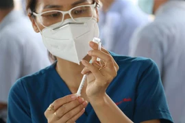 Đội y bác sỹ Trung tâm y tế Quận 7 tiêm vaccine nhắc lại phòng COVID-19 cho công nhân Công ty TNHH Juki Việt Nam (khu chế xuất Tân Thuận, Quận 7, Thành phố Hồ Chí Minh). (Ảnh: Thanh Vũ/TTXVN)