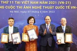 Chủ tịch nước Nguyễn Xuân Phúc trao Huy chương Vàng cho các tác giải đoạt giải. (Ảnh: Thống Nhất/TTXVN)