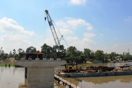 Đơn vị thi công đang đúc hoàn thiện trụ cầu Bến Đình, phần giữa sông Vàm Cỏ Đông. (Ảnh: Lê Đức Hoảnh/TTXVN)