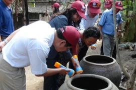 Khảo sát và hướng dẫn các hộ dân diệt muỗi, loăng quăng đúng cách. (Ảnh: Thanh Hòa/TTXVN)