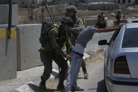 Binh sỹ Israel khám xét người dân Palestine tại một điểm kiểm soát ở trại tị nạn Fawwar ngày 16/8. (Nguồn: THX/TTXVN)