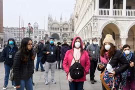 Người dân và khách du lịch đeo khẩu trang phòng tránh dịch COVID-19 tại Venice, Italy, ngày 25/2 vừa qua. (Ảnh: AFP/TTXVN)