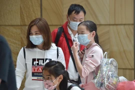 Người dân đeo khẩu trang để phòng tránh lây nhiễm COVID-19 tại sân bay ở Sydney, Australia. (Ảnh: AFP/TTXVN)