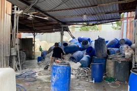 Các bồn và phuy còn tồn đọng chứa nước hóa chất sục rửa tại cơ sở phế liệu khiến nước suối Sọ đổi màu trắng đục gây ô nhiễm môi trường. (Ảnh: Huyền Trang/TTXVN)