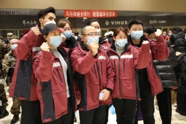 Các nhân viên y tế Trung Quốc chụp ảnh lưu niệm tại Hắc Long Giang trước khi khởi hành tới Hồ Bắc ngày 12/2. (Ảnh: THX/TTXVN)